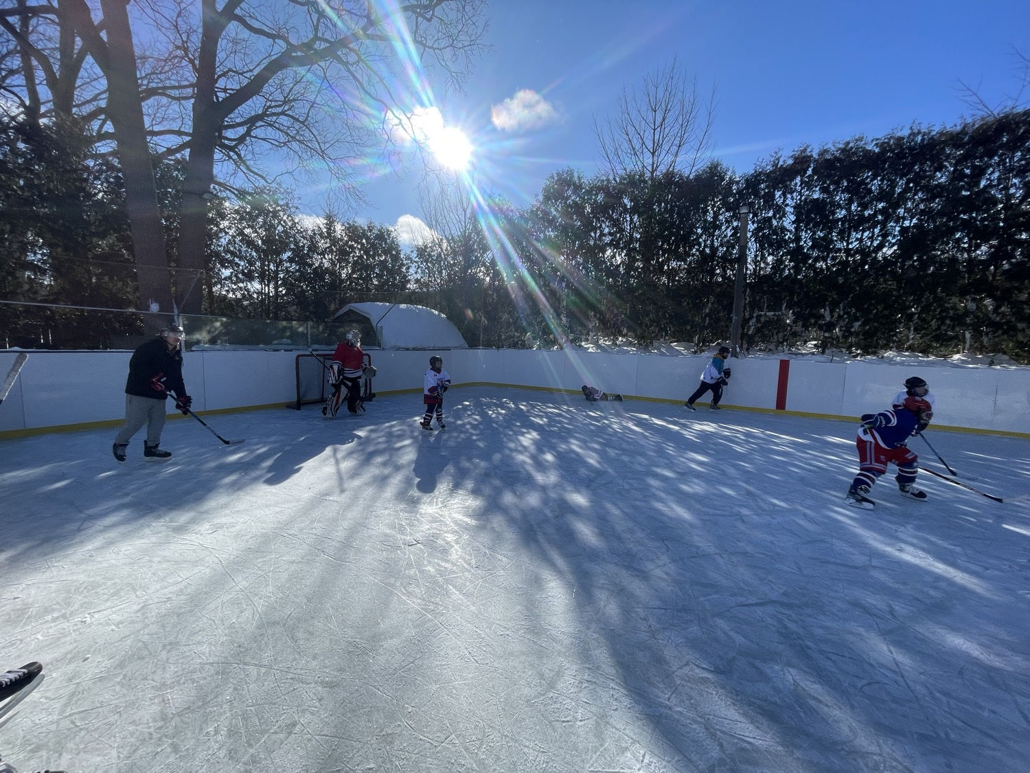 Wide open skate on a bright winter afternoon, long shadows across the ice
